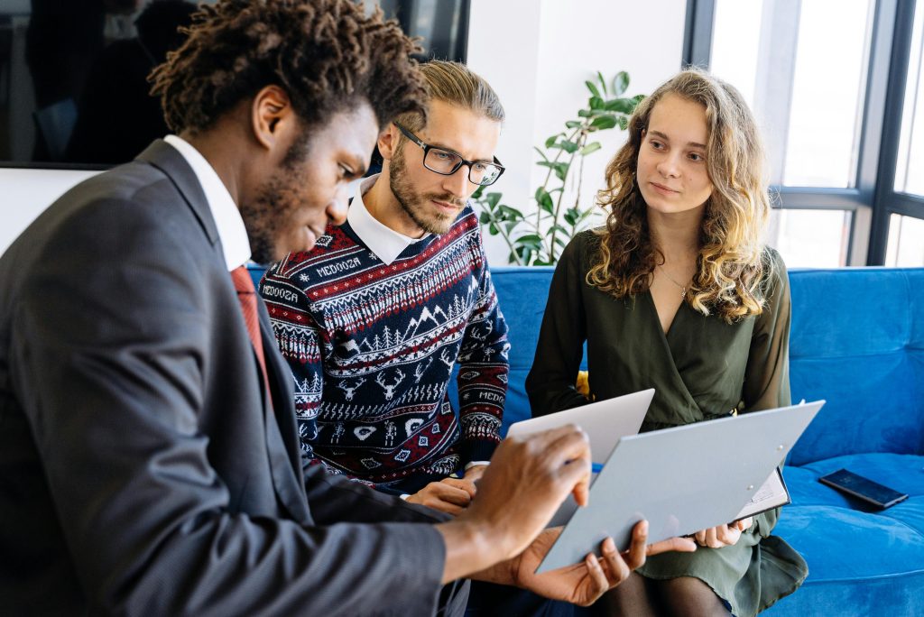 three individuals on a couch reviewing insurance information