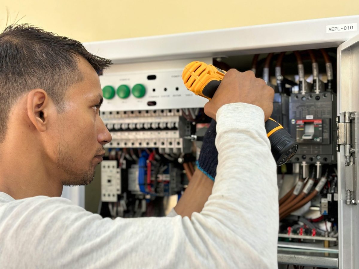 an electrician inspects and repairs an electrical panel