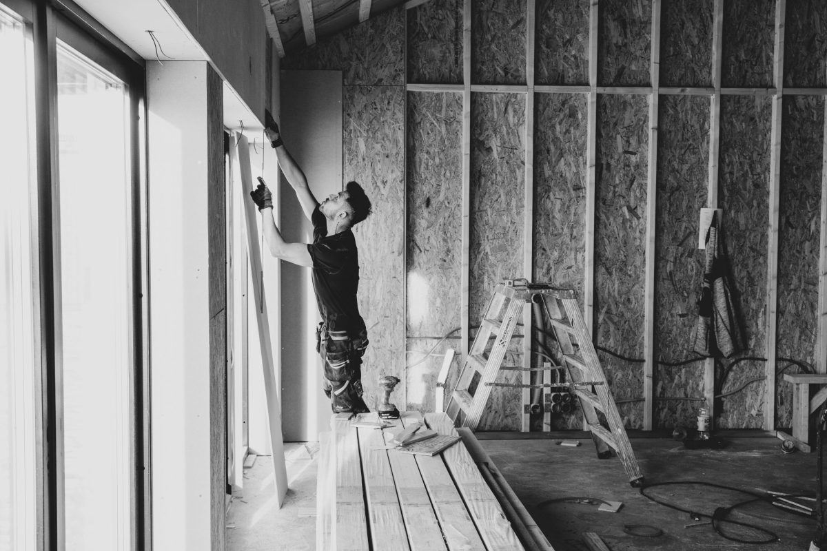 carpenter is repairing a wall in a house