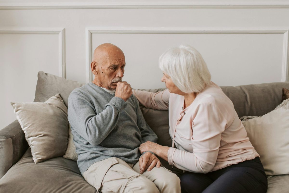 an older couple sitting together on a couch