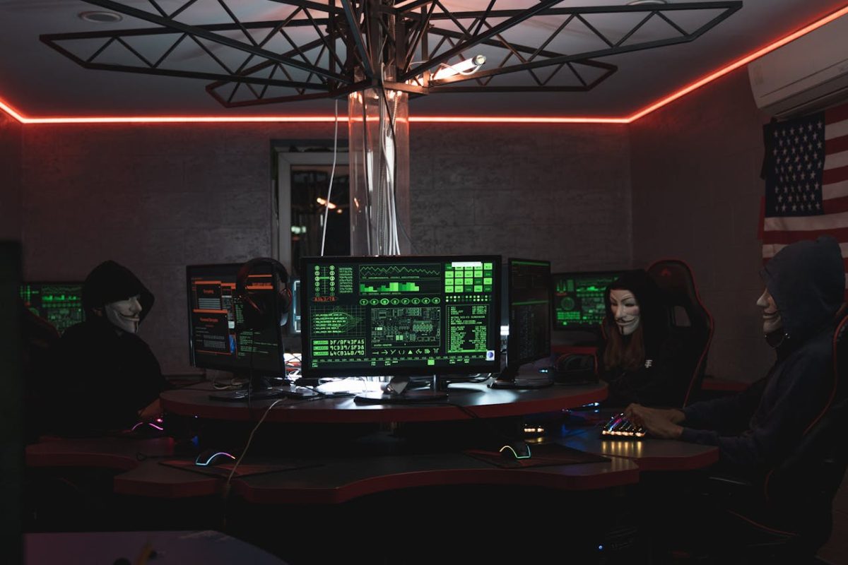 team of individuals engaged with a computer in a shadowy room