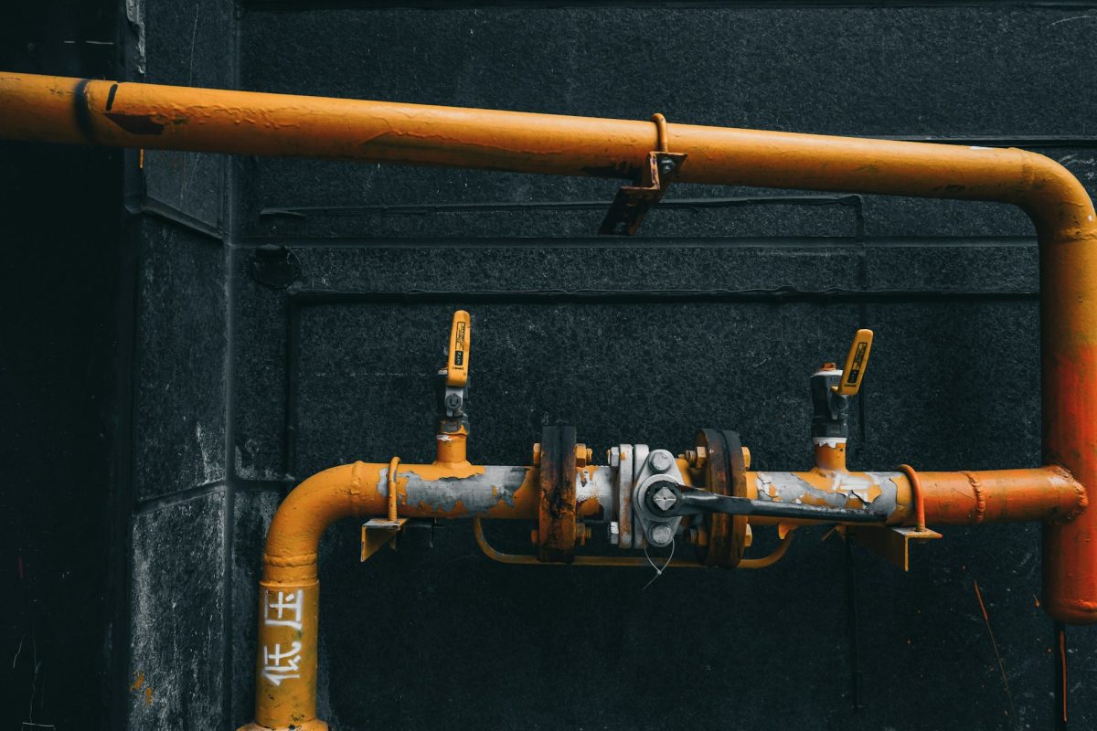 a yellow pipe positioned against a contrasting black wall
