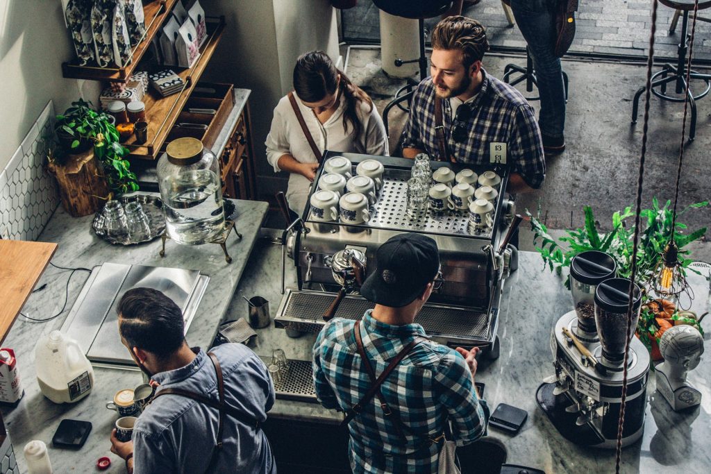 an overhead view of a small coffee shop with baristas working behind the counter