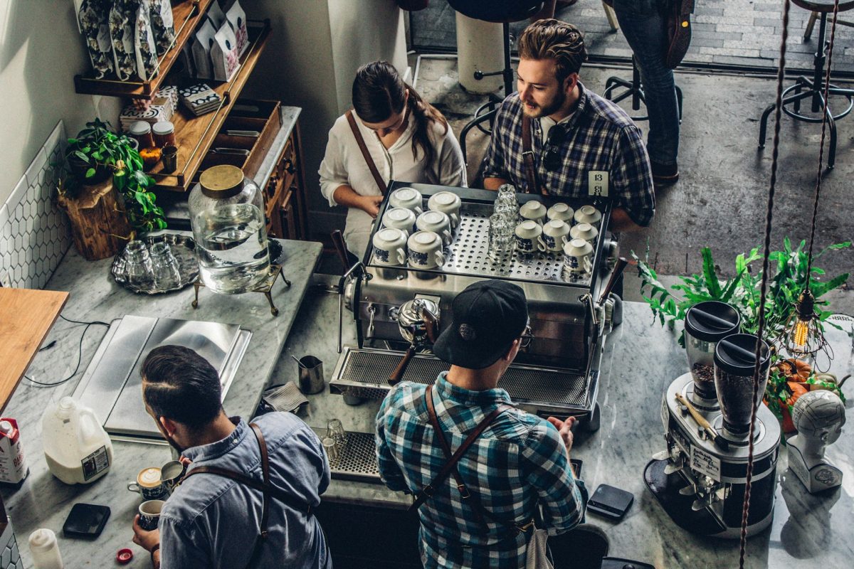 an overhead view of a small coffee shop with baristas working behind the counter