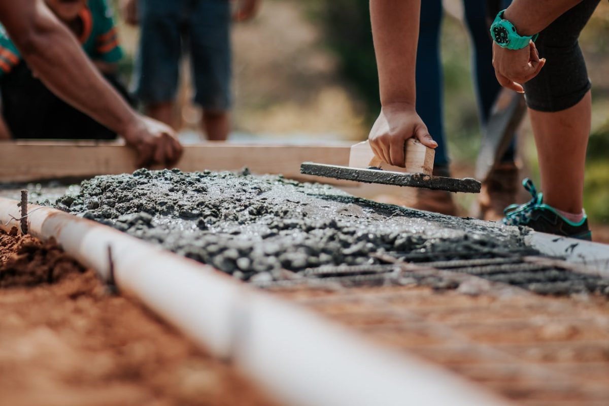 workers engaged in the process of constructing a concrete walkway