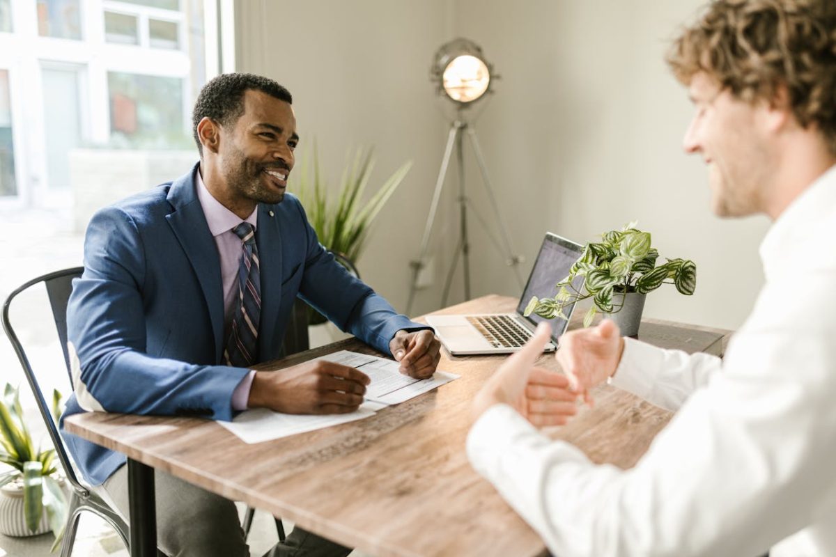 men at a table in an office, focused on their discussion and sharing ideas