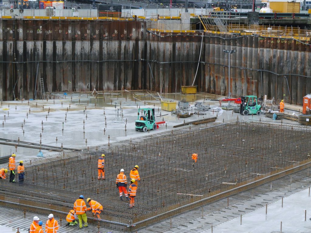 construction workers are actively engaged in building a large concrete structure