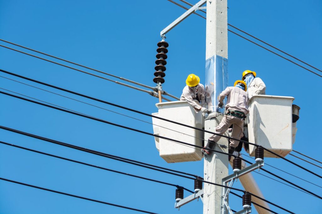 electricians performs essential repairs on a power pole