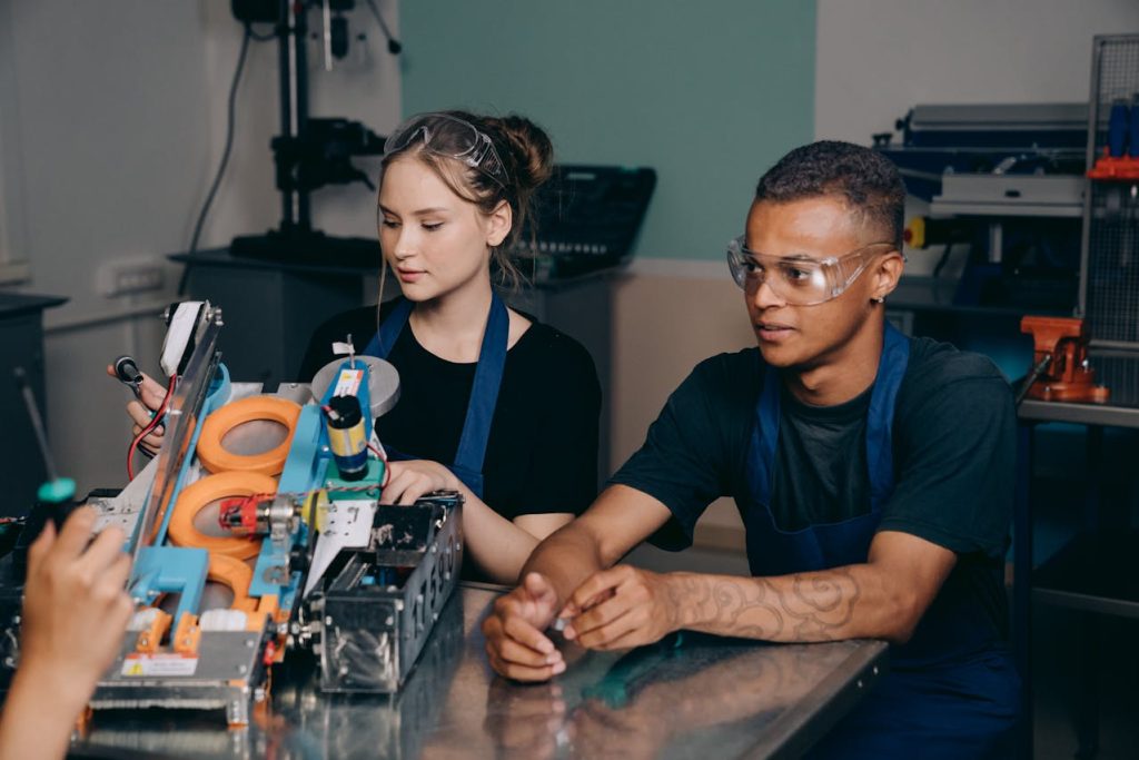 a factory scene featuring two young workers engaged in operating a machine