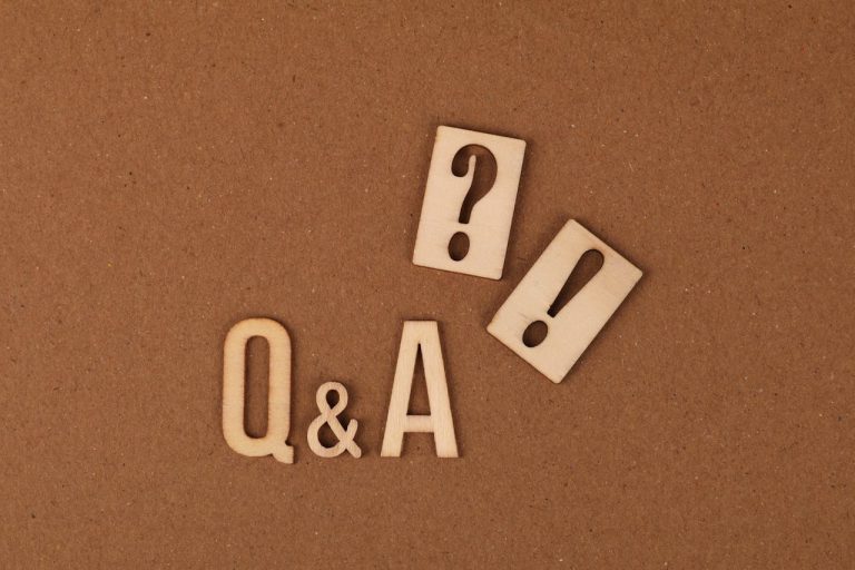close-up of wooden letters forming "Question" and "Answer" against a rich brown backdrop