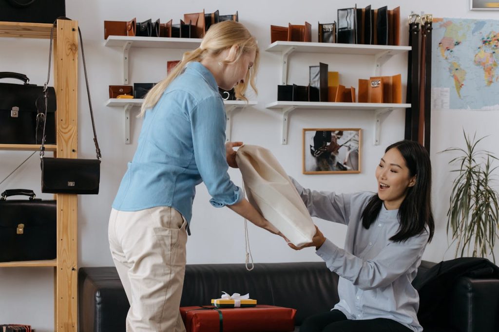 two women sit on a couch, chatting and enjoying each other's company.