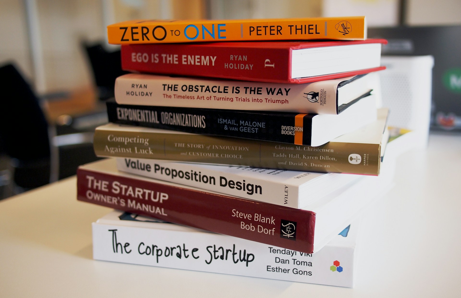 table with a stack of books focused on business insurance for startups and sole traders